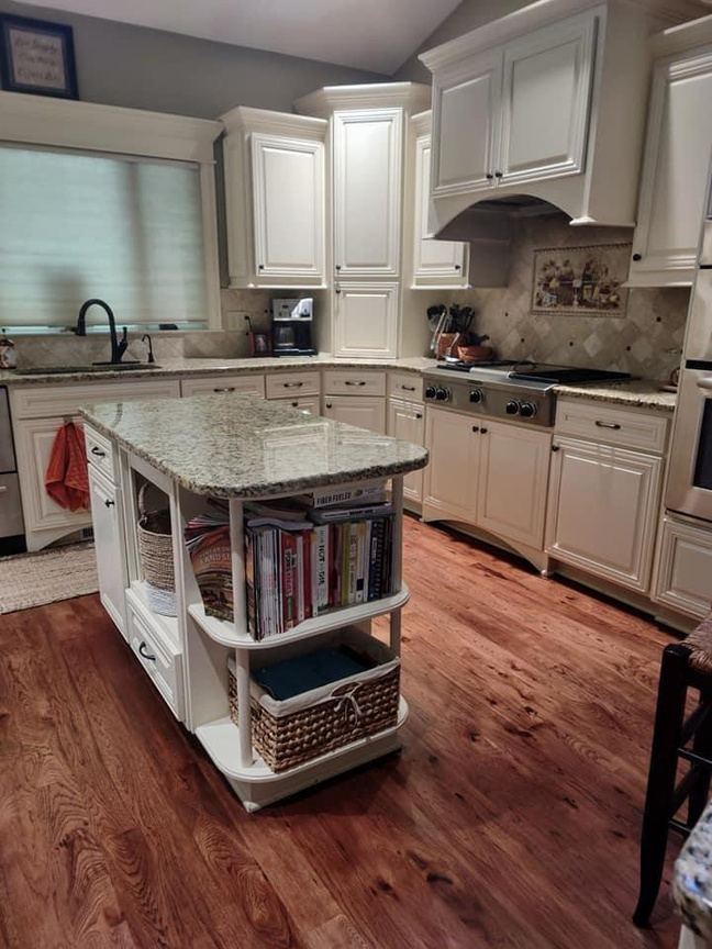 Spotless kitchen with island and hardwood floors